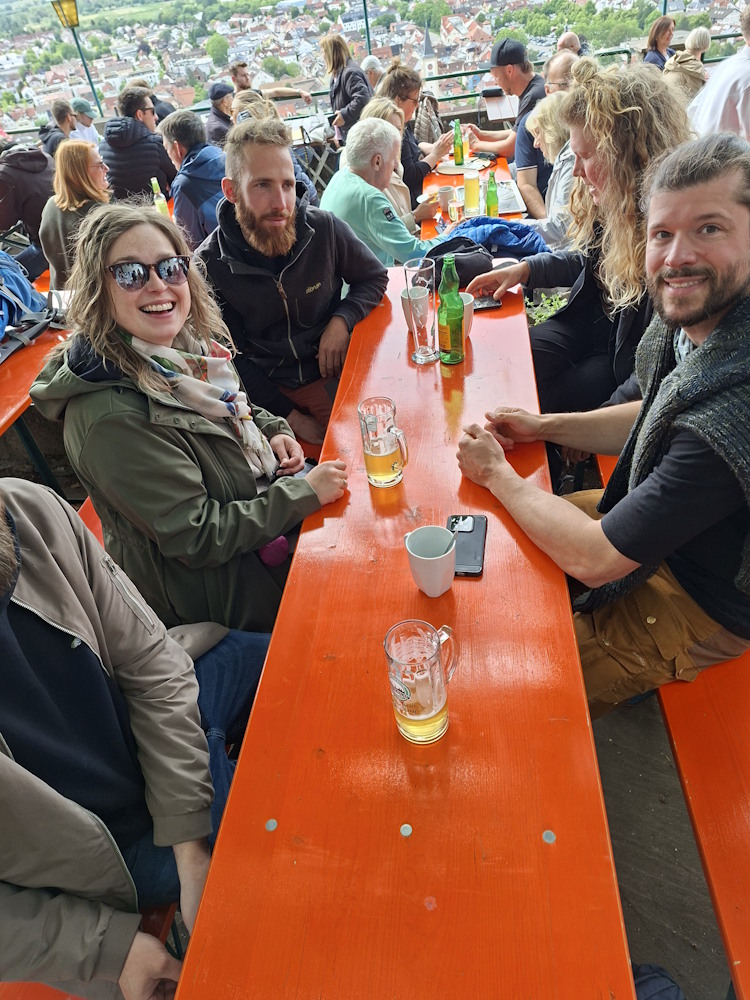 Menschen auf der Terrasse der Strahlenburg, bei Kaffee, Bier oder einem Glas Wein.