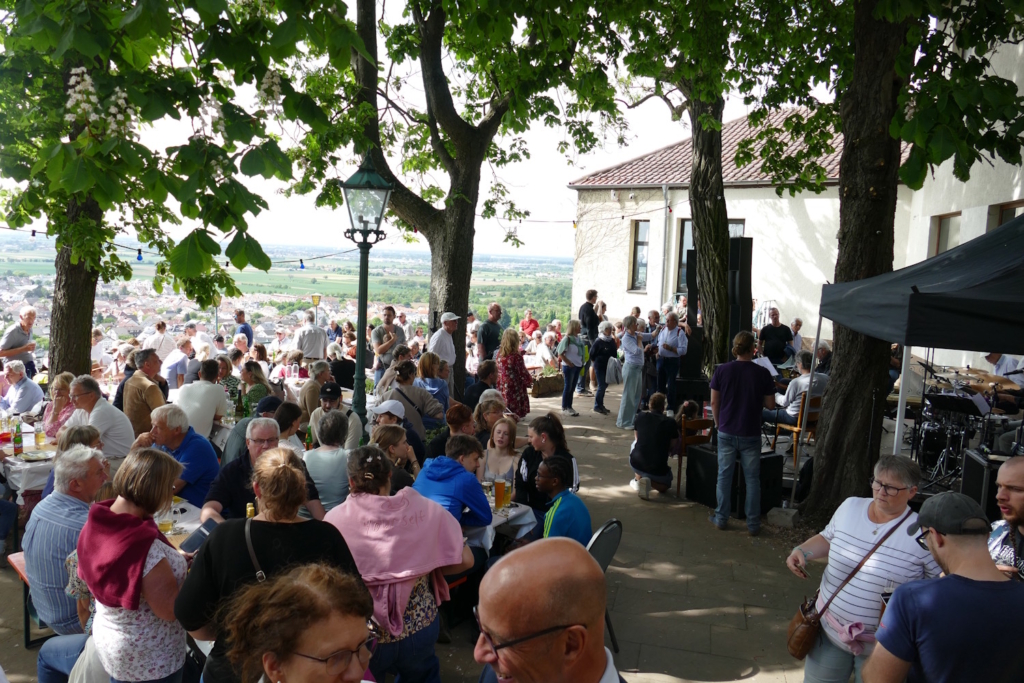 Besucher sitzen und stehen bei einem Burgfest auf der Strahlenburg